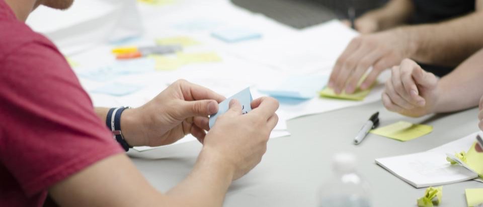 A programme team working around a table covered with notes